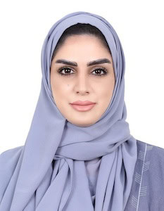 Eli Ovits wearing a light blue hijab, looking directly at the camera.