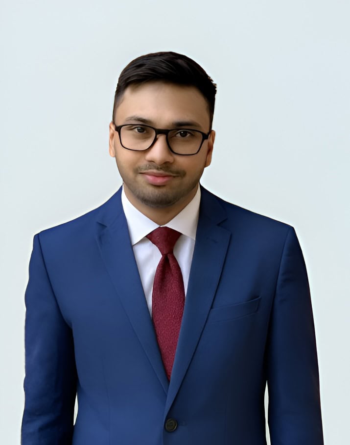 Eli Ovits in formal business attire, wearing glasses, posing confidently for a professional profile.